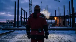 Construction worker in a Milwaukee heated jacket with an M12 battery at the belt on a frosty job site